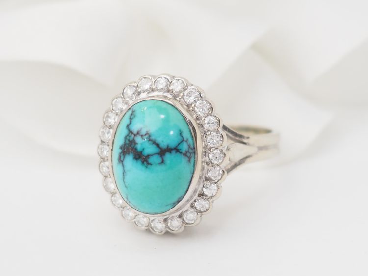 Anello con contorno in oro bianco, diamanti e turchese cabochon