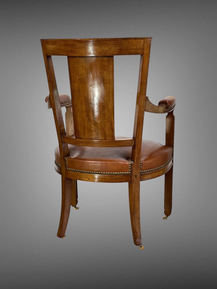 Empire-style armchair in walnut decorated with gilt bronze and covered in brown leather