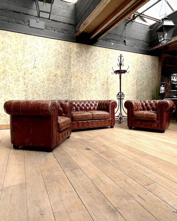 Salon chesterfield avec un canapé et deux fauteuils