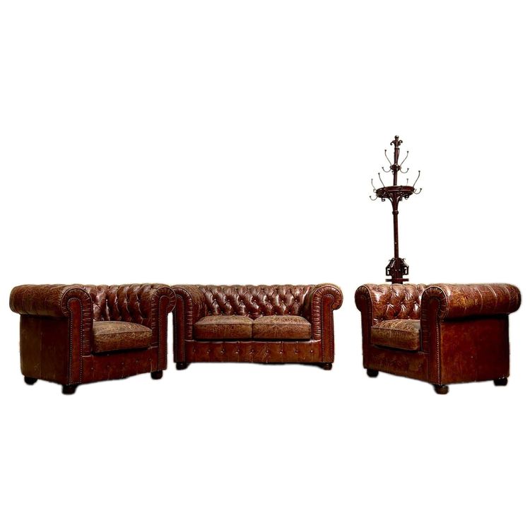 Salon chesterfield avec un canapé et deux fauteuils