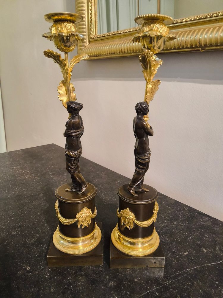 Pair of Candlesticks with Antique Figures and Poppies in patinated and gilded bronze, Directoire period.