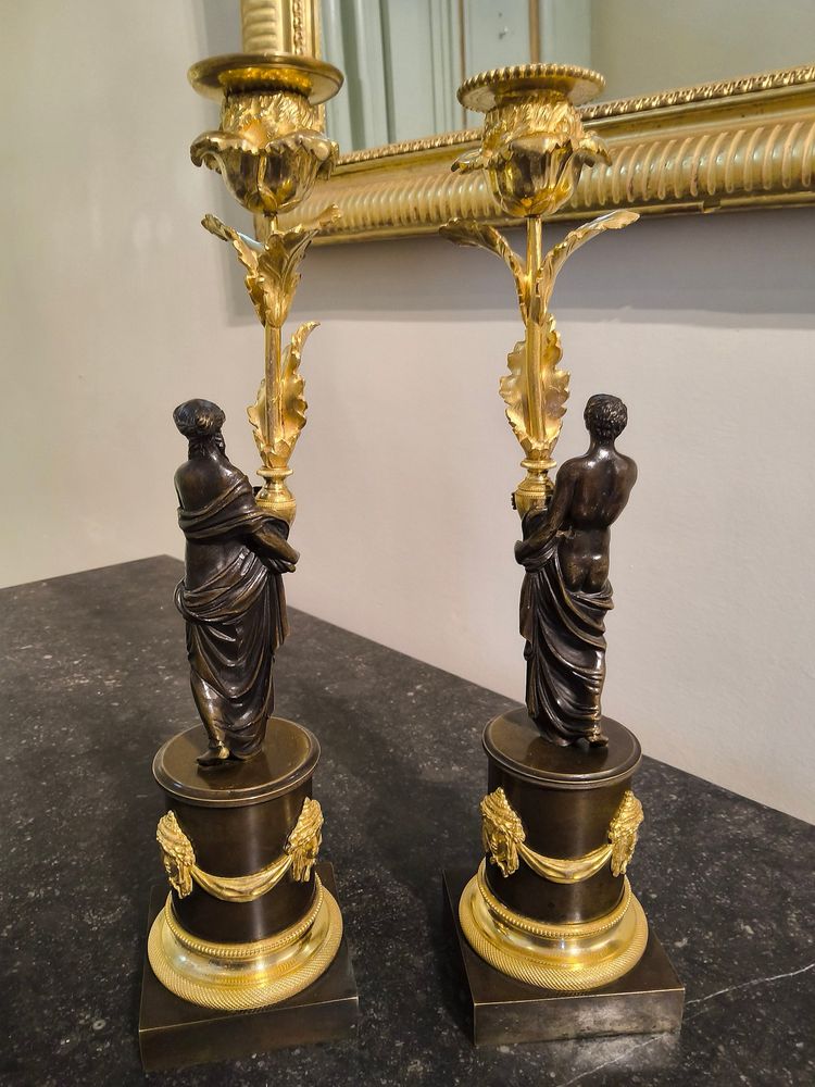 Pair of Candlesticks with Antique Figures and Poppies in patinated and gilded bronze, Directoire period.