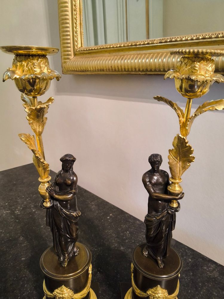 Pair of Candlesticks with Antique Figures and Poppies in patinated and gilded bronze, Directoire period.