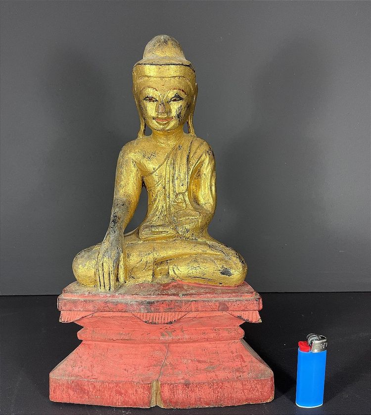 Birma, Mitte des 20. Jahrhunderts, rot und gold lackierte Holzskulptur, die einen sitzenden Buddha darstellt.
