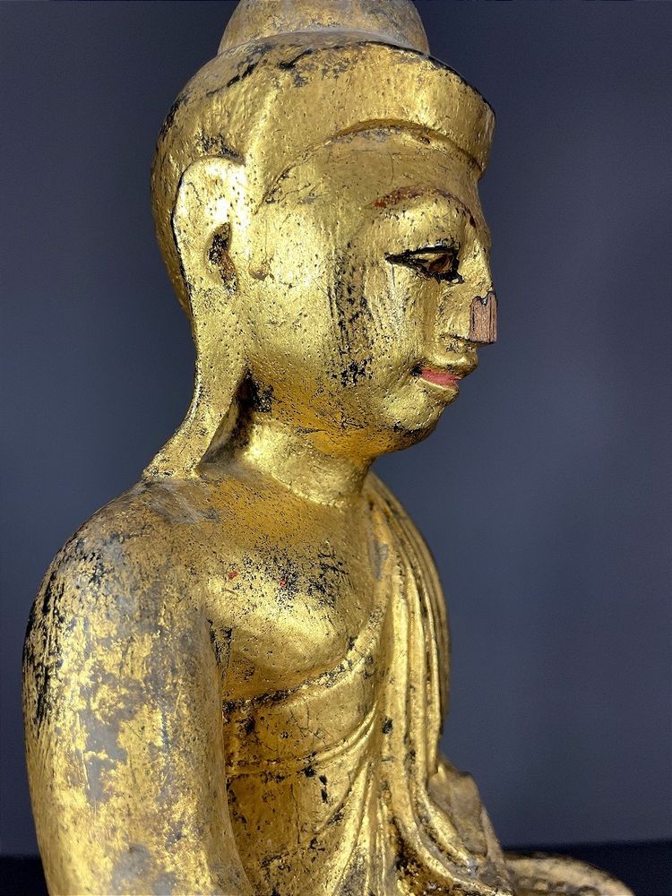 Birma, Mitte des 20. Jahrhunderts, rot und gold lackierte Holzskulptur, die einen sitzenden Buddha darstellt.
