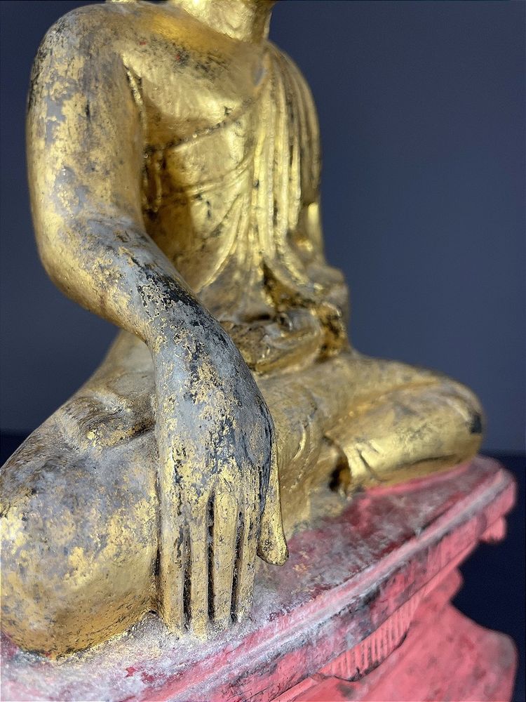 Birma, Mitte des 20. Jahrhunderts, rot und gold lackierte Holzskulptur, die einen sitzenden Buddha darstellt.