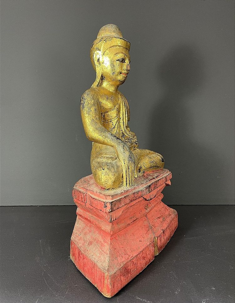 Birma, Mitte des 20. Jahrhunderts, rot und gold lackierte Holzskulptur, die einen sitzenden Buddha darstellt.