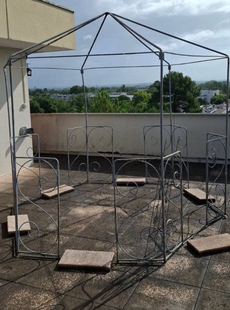 Alte Gartenlaube aus bemaltem Metall in sechseckiger Form