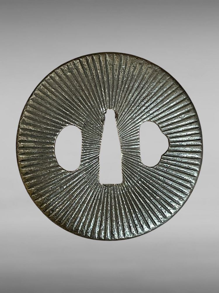 Tsuba Maru Gata in ferro battuto con motivo radiante - Periodo Edo (1603-1868).