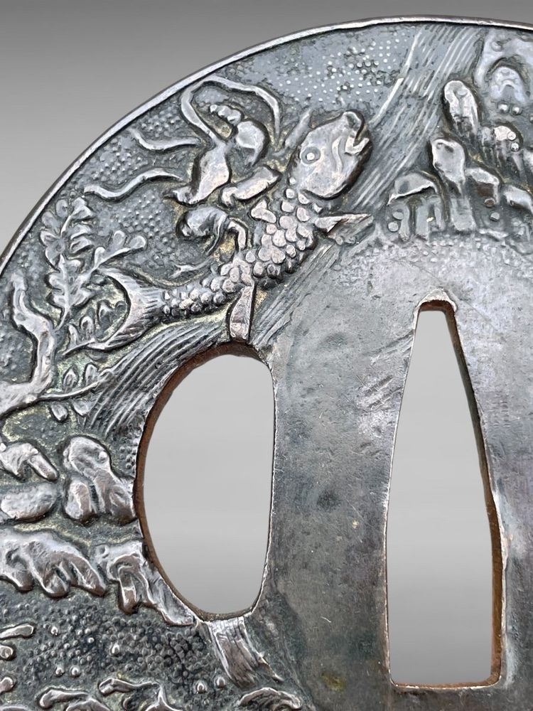 Tsuba Maru Gata in ferro battuto con due pescatori su sfondo Nanako - Periodo Edo (1603-1868)