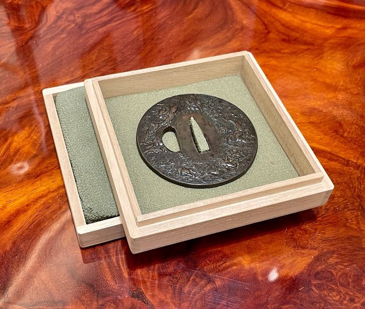 Tsuba Maru Gata in ferro battuto con due pescatori su sfondo Nanako - Periodo Edo (1603-1868)
