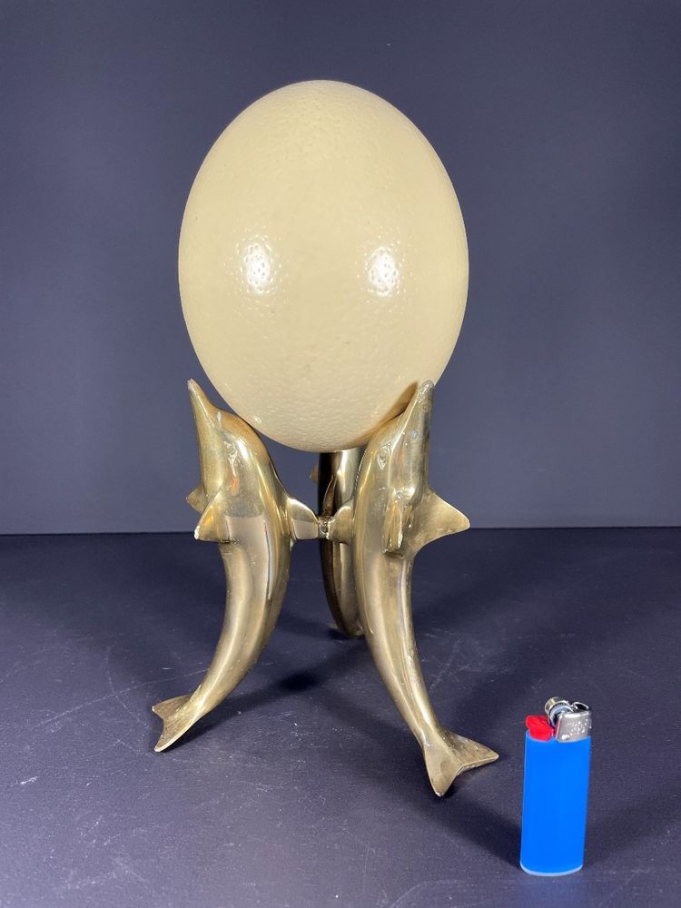 France, Ostrich egg mounted on a brass tripod base with a representation of dolphins, 1970.