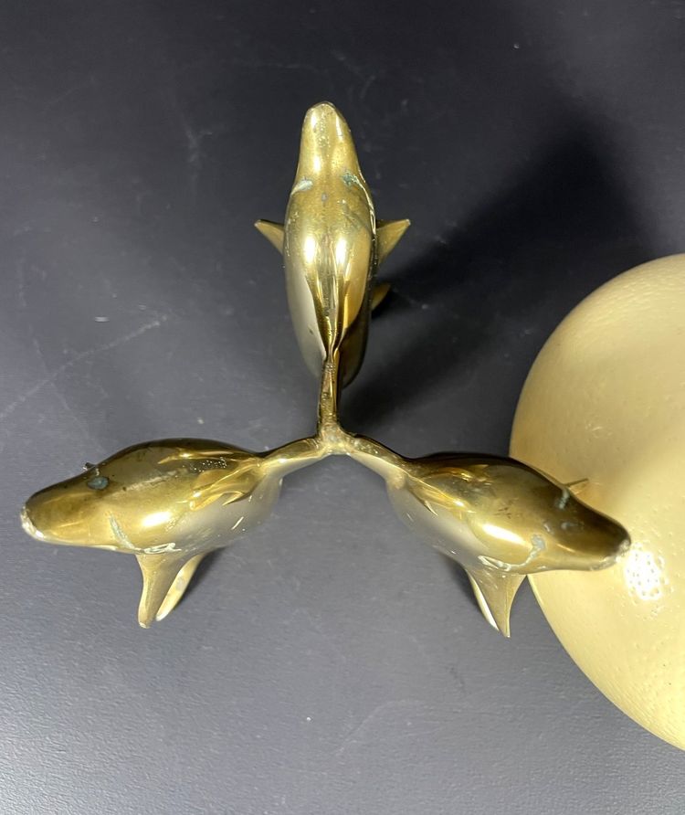 France, Ostrich egg mounted on a brass tripod base with a representation of dolphins, 1970.