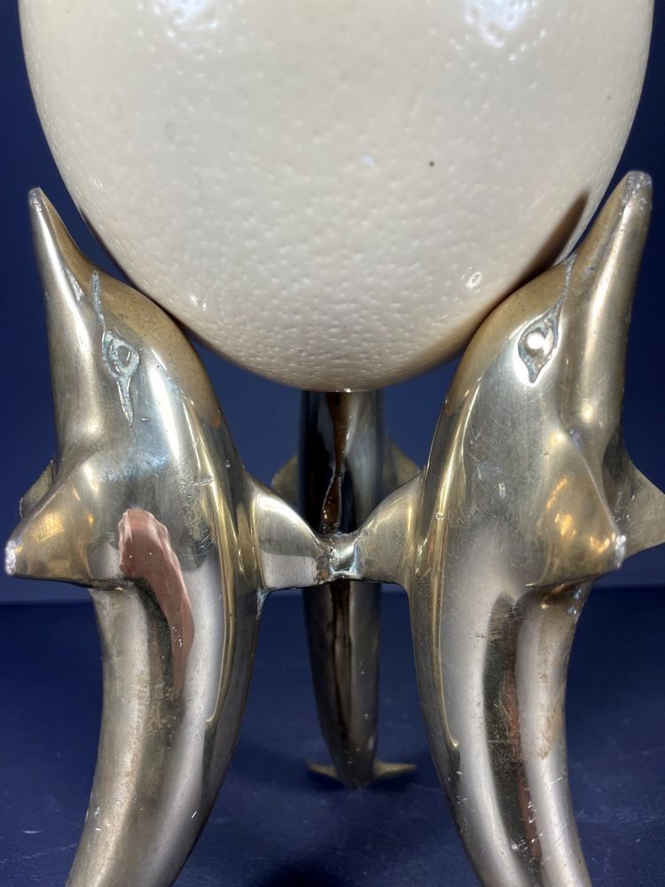 France, Ostrich egg mounted on a brass tripod base with a representation of dolphins, 1970.