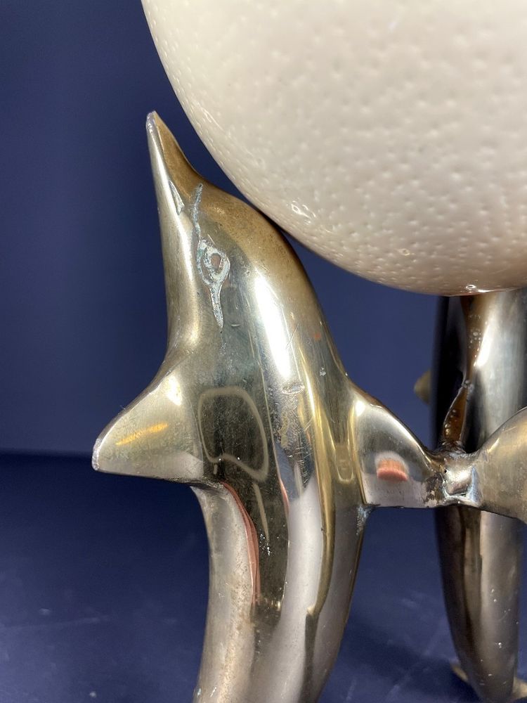 France, Ostrich egg mounted on a brass tripod base with a representation of dolphins, 1970.