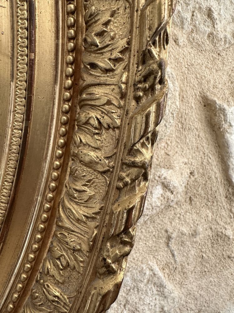 Glace ovale dorée de style Louis XVI