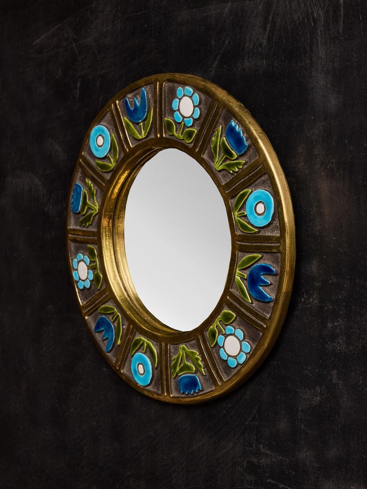 Round ceramic mirror by Mithe Espelt with blue flower decorations