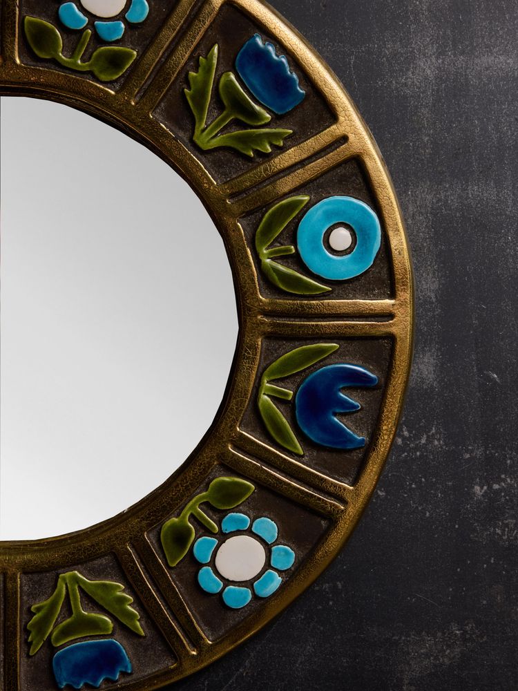 Round ceramic mirror by Mithe Espelt with blue flower decorations