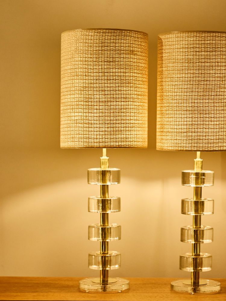 Pair of stacked solid glass disc table lamps with polished brass columns
