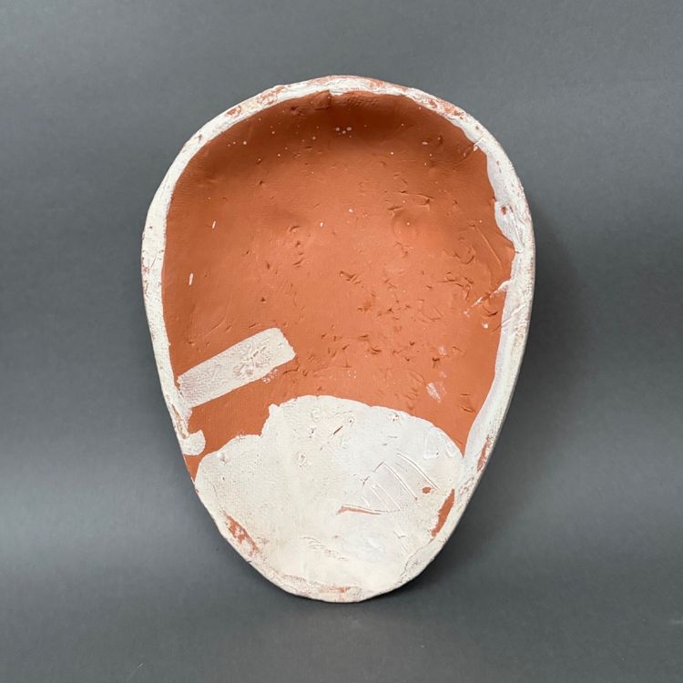 Maschera africanista in terracotta smaltata bianca firmata Colette