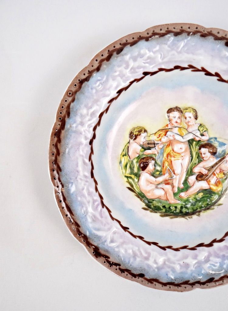 Assiette Capodimonte en porcelaine bas-relief de chérubin polychrome début XXe