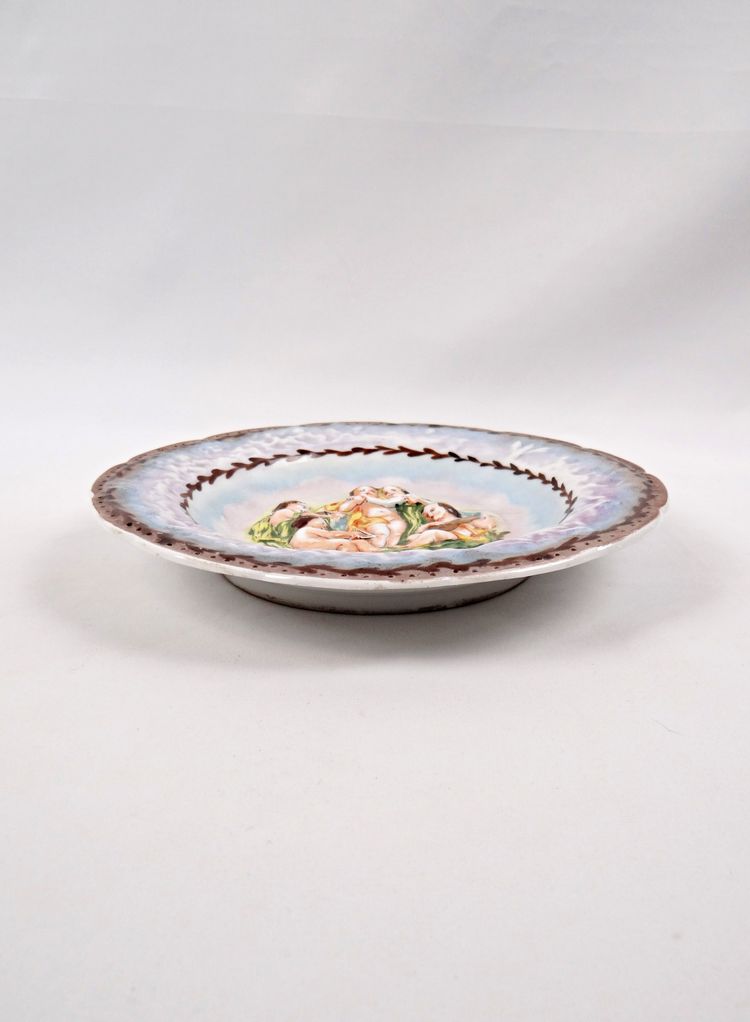 Assiette Capodimonte en porcelaine bas-relief de chérubin polychrome début XXe