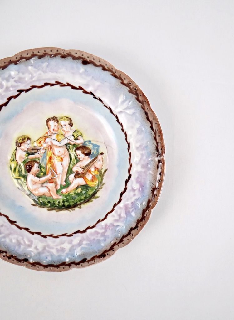 Assiette Capodimonte en porcelaine bas-relief de chérubin polychrome début XXe