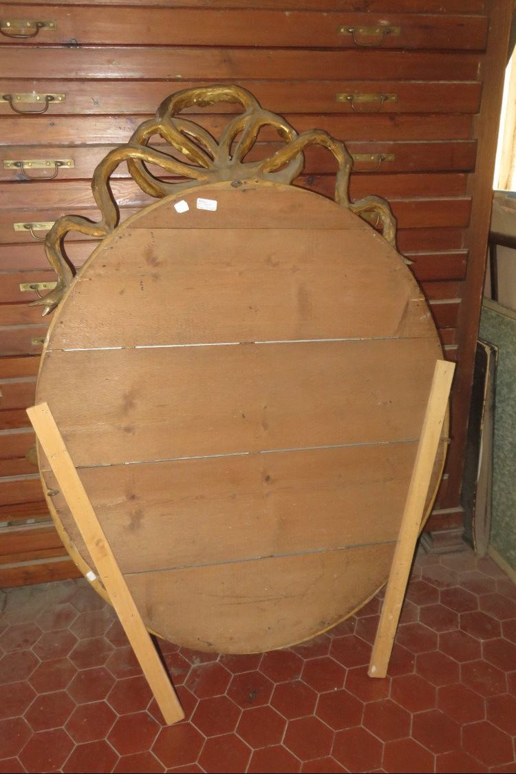 Grande specchio ovale con frontone, in legno dorato, XIX secolo.
