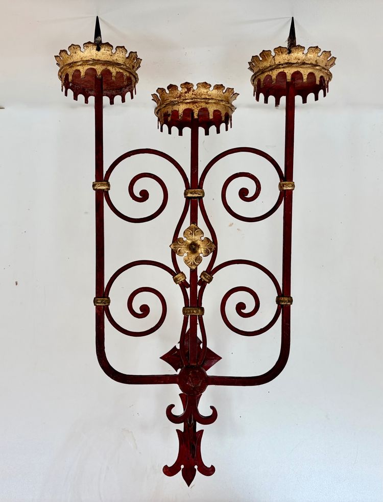 PAIR OF WROUGHT IRON CANDLE-SOCKET WALL LIGHTS, STAINED RED AND GOLD.