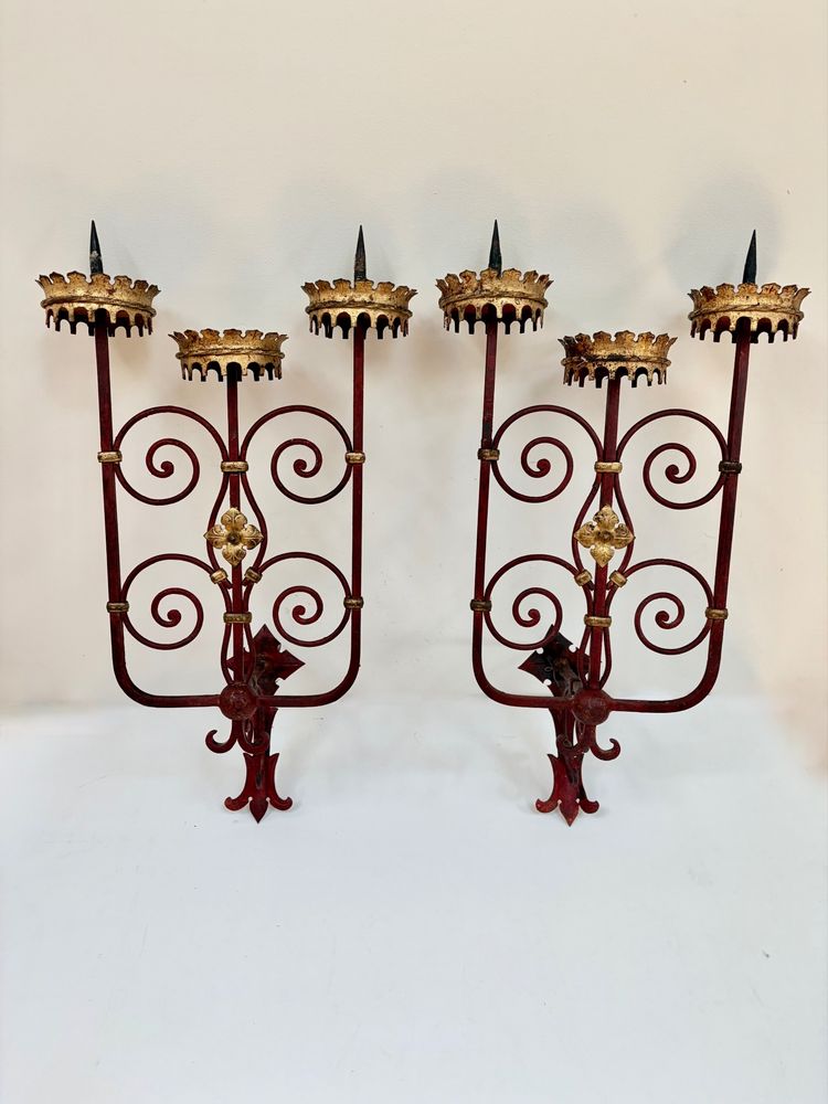 PAIR OF WROUGHT IRON CANDLE-SOCKET WALL LIGHTS, STAINED RED AND GOLD.