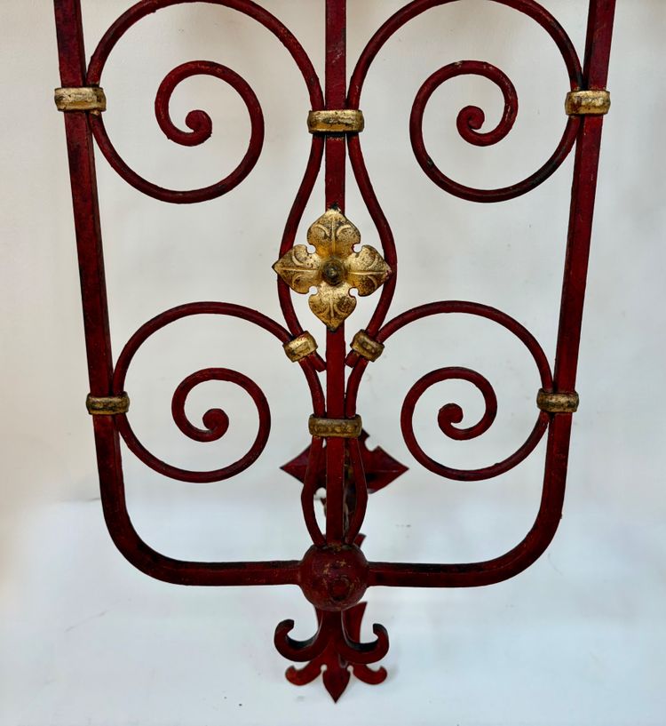 PAIR OF WROUGHT IRON CANDLE-SOCKET WALL LIGHTS, STAINED RED AND GOLD.