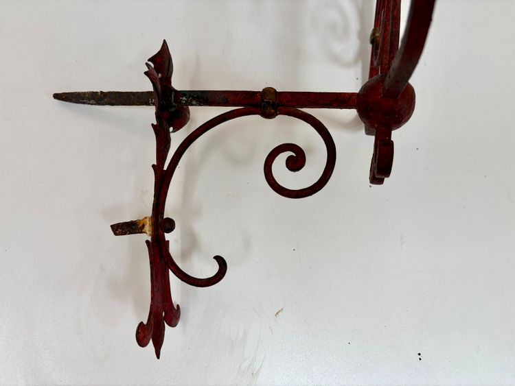 PAIR OF WROUGHT IRON CANDLE-SOCKET WALL LIGHTS, STAINED RED AND GOLD.