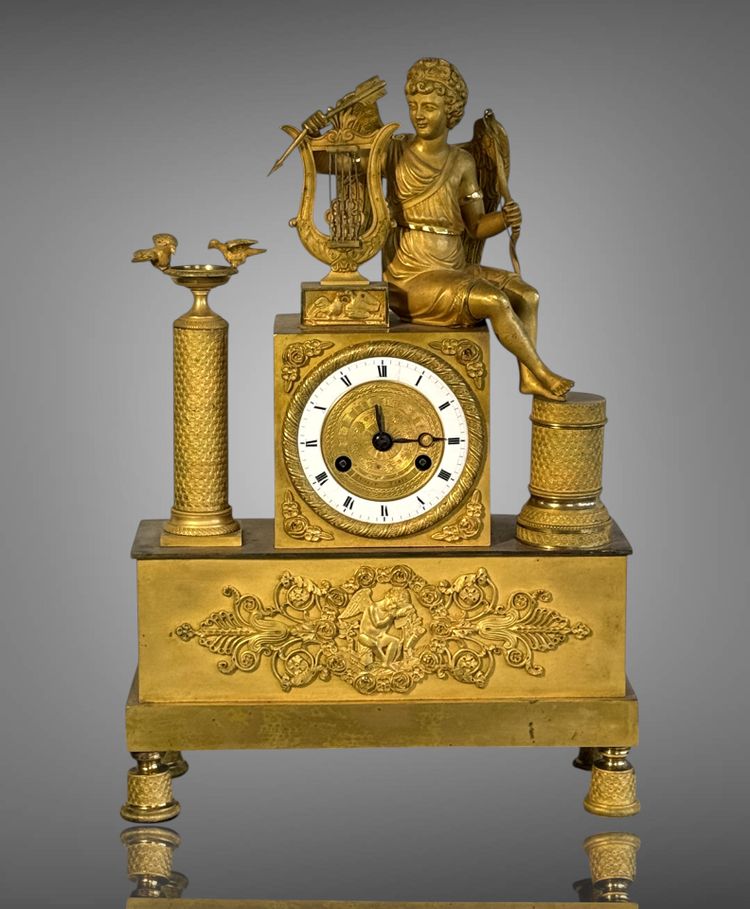 PENDULE ÉPOQUE EMPIRE EN BRONZE DORÉ A DECOR D'EROS JOUANT DE LA HARPE