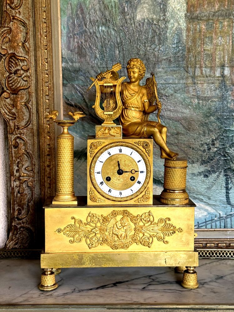 PENDULE ÉPOQUE EMPIRE EN BRONZE DORÉ A DECOR D'EROS JOUANT DE LA HARPE