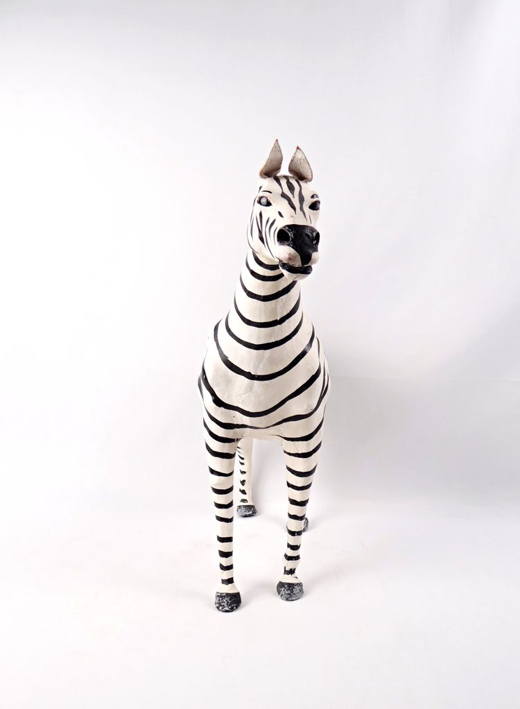 Scultura in cuoio dipinto raffigurante una zebra con occhi di vetro nero, Kenya, metà del XX secolo.
