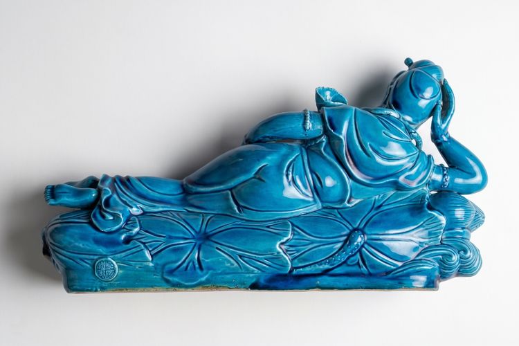Peacock blue Guanyin resting on a lotus bed
