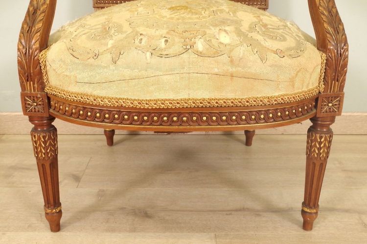 PAIRE DE FAUTEUILS LOUIS XVI EN NOYER DORÉ, TAPISSERIE AU PETIT POINT