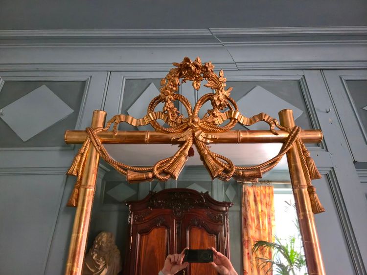 Miroir d'époque Napoléon III à l'imitation du bambou et à décor de draperies à houppes.