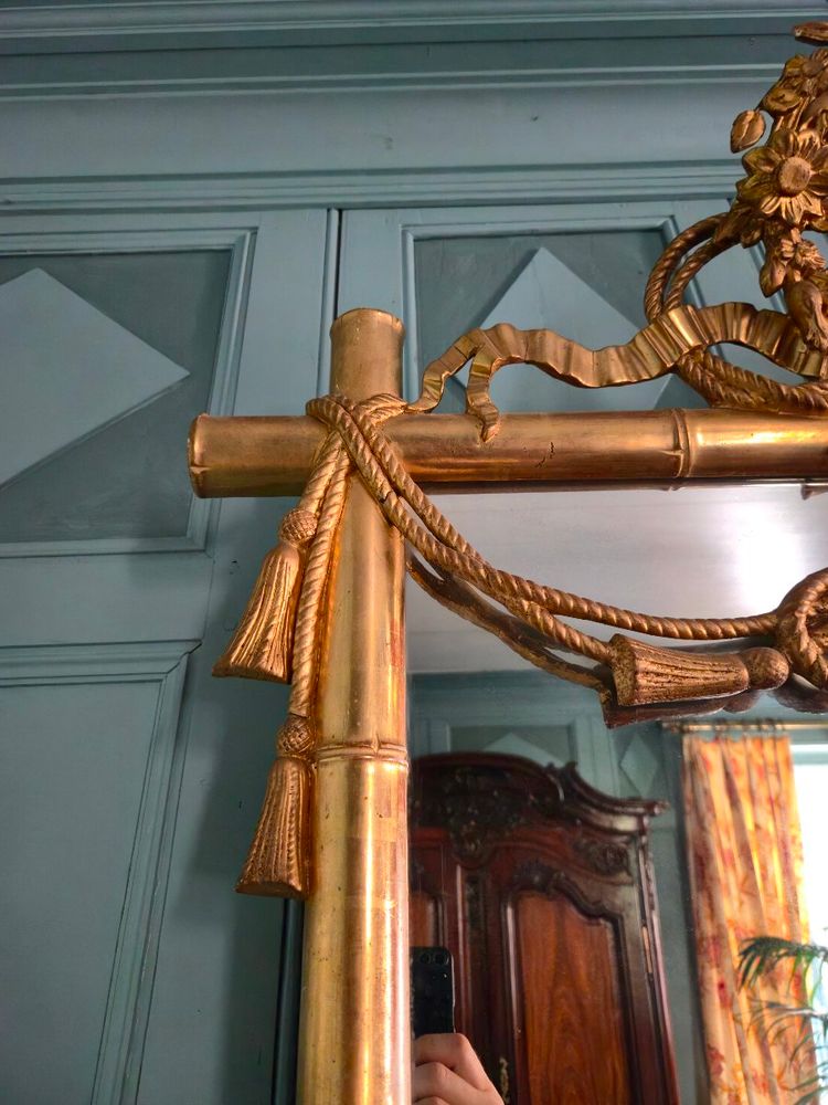 Miroir d'époque Napoléon III à l'imitation du bambou et à décor de draperies à houppes.