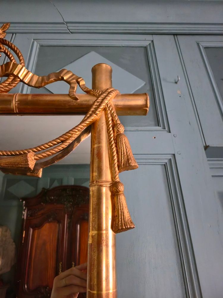 Miroir d'époque Napoléon III à l'imitation du bambou et à décor de draperies à houppes.