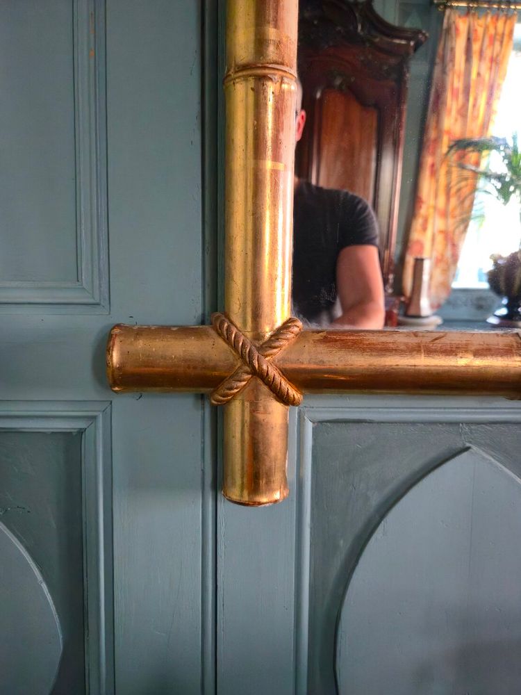 Miroir d'époque Napoléon III à l'imitation du bambou et à décor de draperies à houppes.