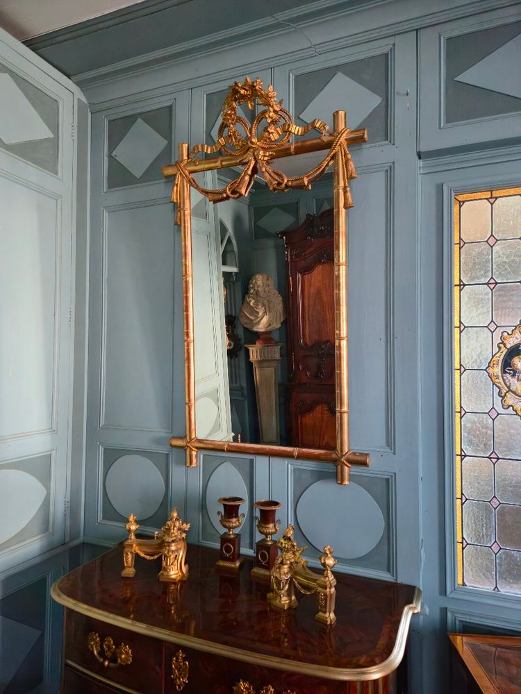 Miroir d'époque Napoléon III à l'imitation du bambou et à décor de draperies à houppes.