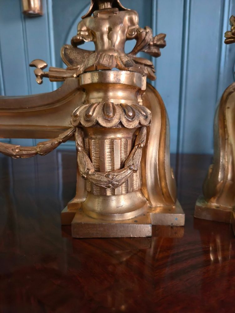 Paire de têtes de chenets aux trophées d'armes en bronze doré, transition Louis XV-Louis XVI