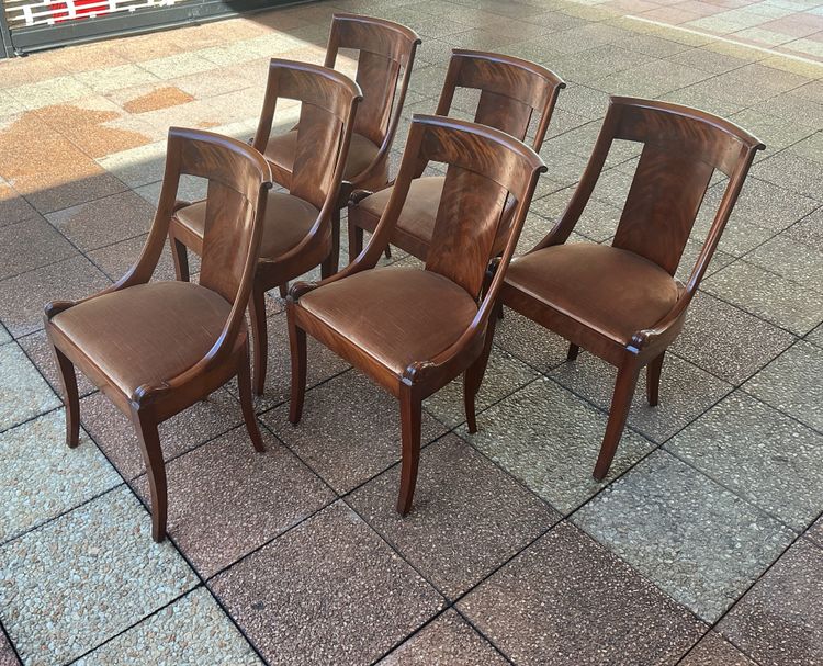 Six varnished mahogany chairs with curved backs.