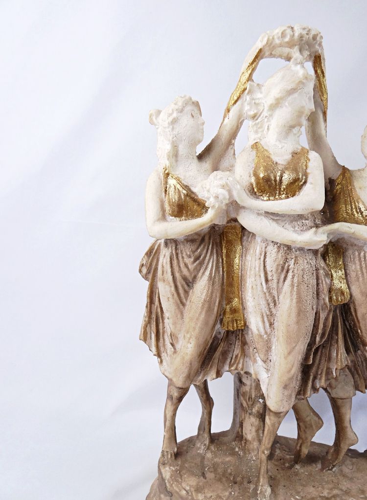 Sculpture titled "The Three Graces," made of white and gold resin, 20th century