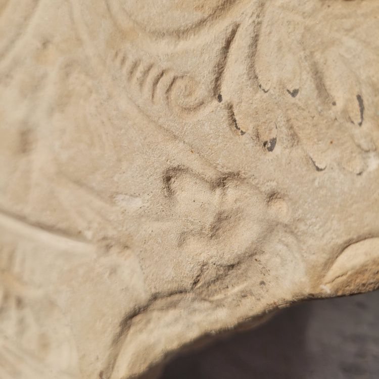Round stone carved on each face, probably 17th century