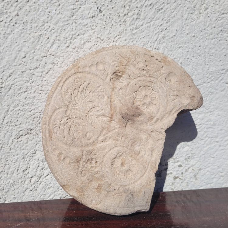 Round stone carved on each face, probably 17th century