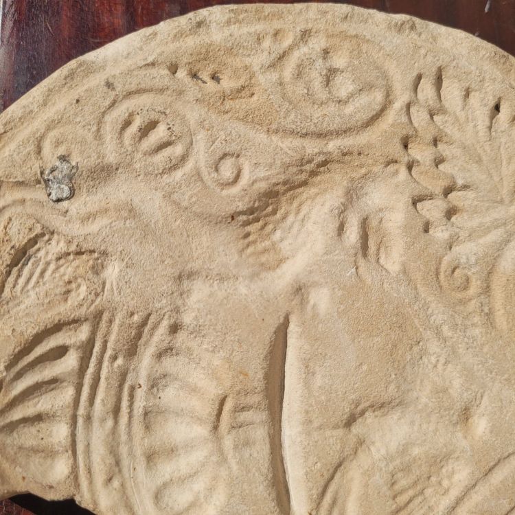 Round stone carved on each face, probably 17th century
