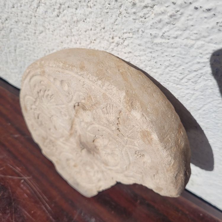 Round stone carved on each face, probably 17th century