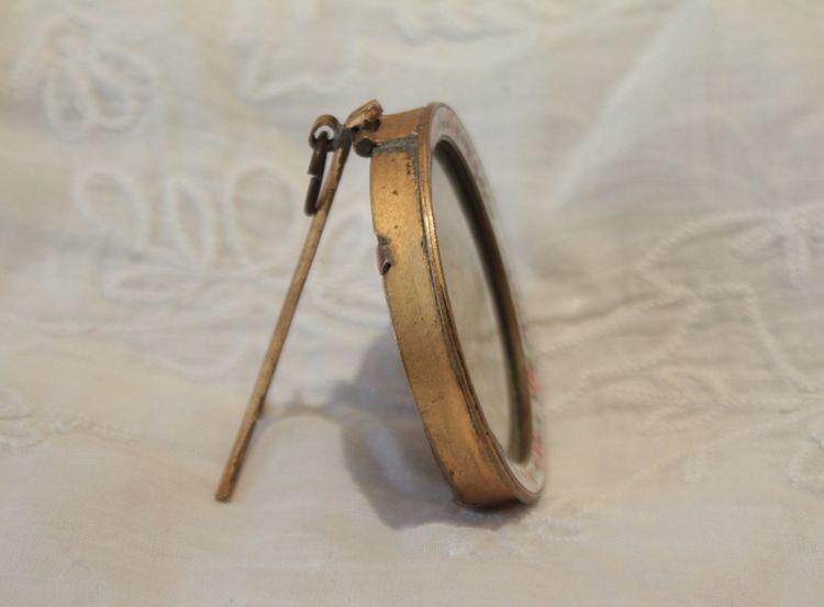 Circular enameled brass photo frame, circa 1900